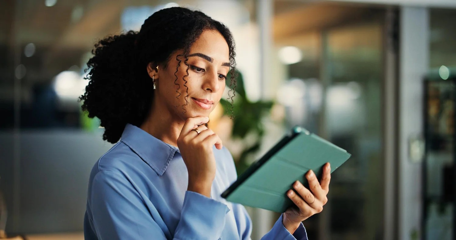 Como Consultar Protesto de Empresa pelo CNPJ Como Consultar Protesto de Empresa pelo CNPJ: mulher consultando um tablet em um ambiente de trabalho